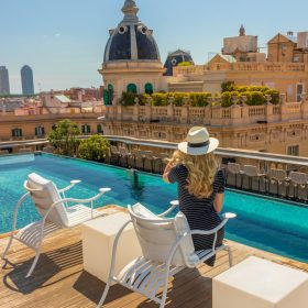 woman in black and white stripe dress standing beside swimming pool during daytime